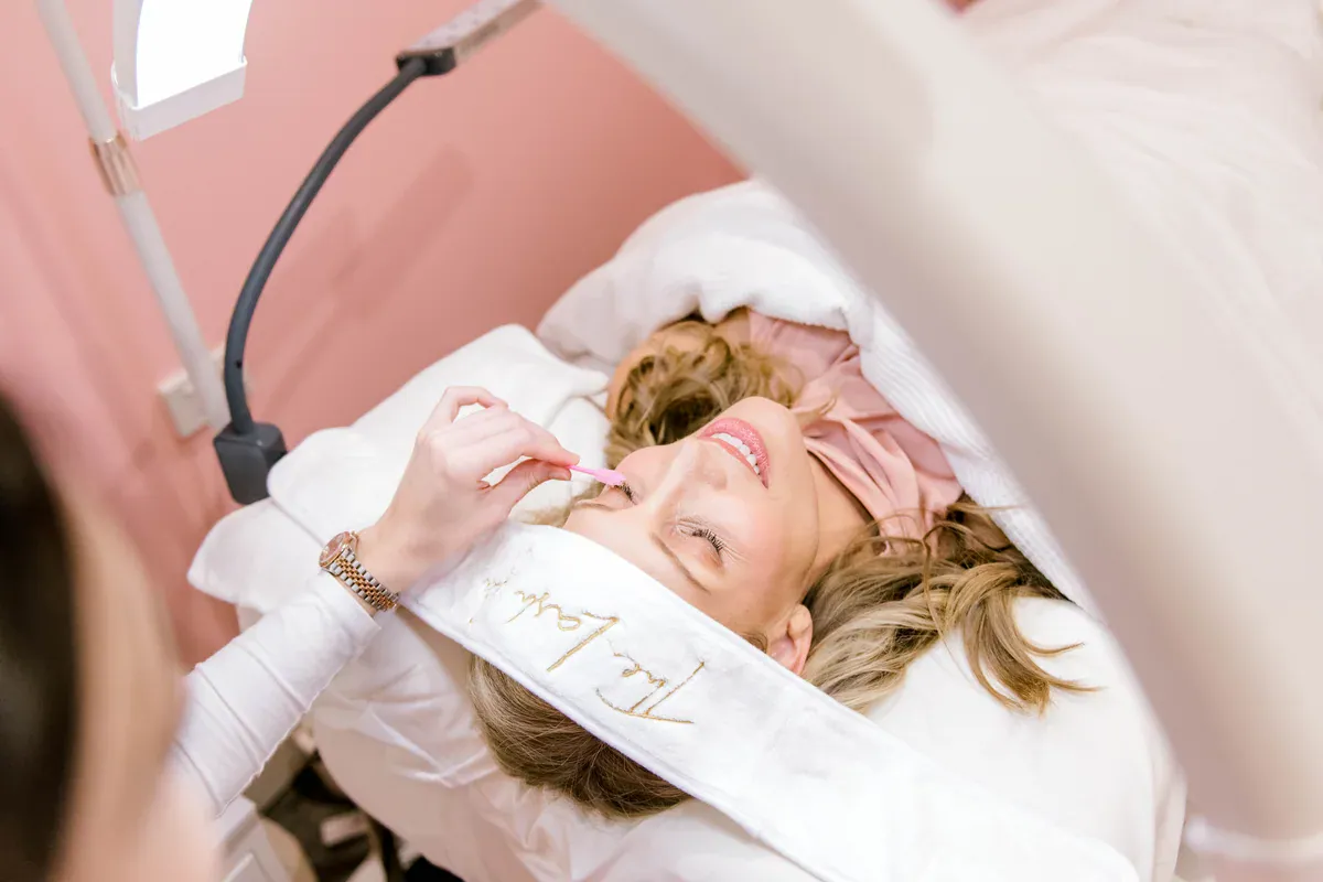 Lash artist brushing a client's lashes during a treatment at The Lash Spa.