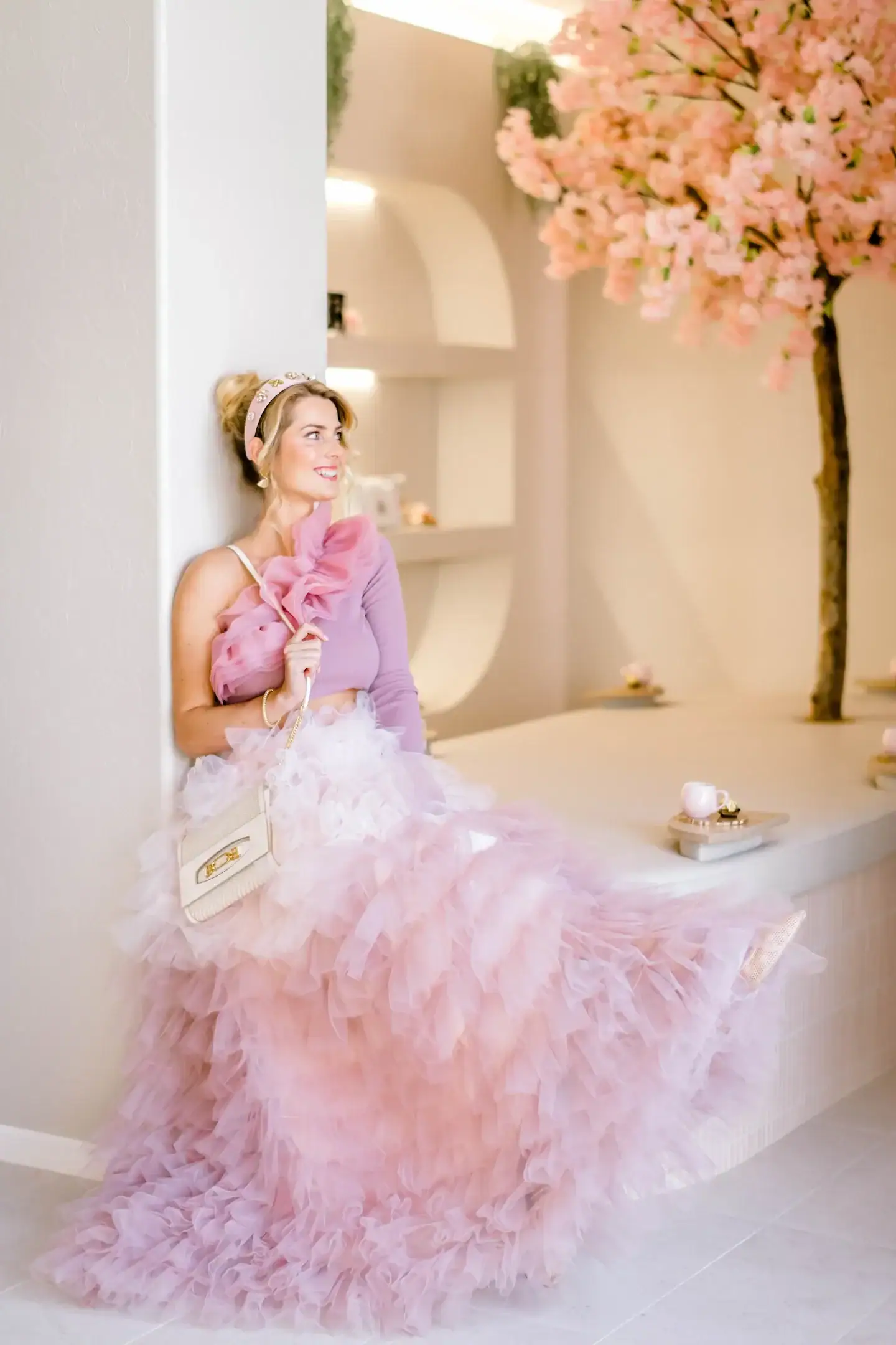 Woman seated in The Lash Spa reception beside the pink cherry blossom tree
